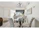 Dining area with modern chandelier, gray patterned chairs and glass table near kitchen at 413 Meadow Ln # 81, Oldsmar, FL 34677
