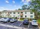 Two-story condo exterior featuring well-maintained landscaping, individual entrances, and reserved parking spaces at 413 Meadow Ln # 81, Oldsmar, FL 34677