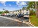 Well-maintained condo exterior with parking for residents and visitors, nestled amidst lush greenery and tall trees at 413 Meadow Ln # 81, Oldsmar, FL 34677