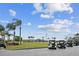 Golf course view with several golf carts lined up and green open space and blue skies at 413 Meadow Ln # 81, Oldsmar, FL 34677