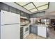 Updated kitchen with gray cabinets, white appliances, and an open view to the living room at 413 Meadow Ln # 81, Oldsmar, FL 34677