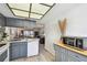 Kitchen view with gray cabinets, stainless steel microwave, and breakfast bar at 413 Meadow Ln # 81, Oldsmar, FL 34677
