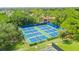View of the outdoor tennis courts with green and blue surfaces within a well-maintained residential area at 413 Meadow Ln # 81, Oldsmar, FL 34677