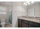 Bright bathroom with granite countertop, dark cabinets and a shower/tub combo with curtain at 4264 Bexley Village Dr, Land O Lakes, FL 34638