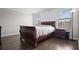 Spacious bedroom with hardwood floors, a statement headboard, and views of the outdoor landscape at 4264 Bexley Village Dr, Land O Lakes, FL 34638