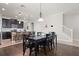 Open dining area with dark wood floors, a large table, and adjacent kitchen featuring an island at 4264 Bexley Village Dr, Land O Lakes, FL 34638