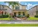 Inviting two-story home with a cozy front porch, beautiful landscaping, and a well-manicured lawn at 4264 Bexley Village Dr, Land O Lakes, FL 34638