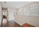 Well-lit hallway with hardwood floors, windows, and a glimpse into an inviting bedroom at 4264 Bexley Village Dr, Land O Lakes, FL 34638
