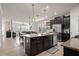 Open-concept kitchen featuring a large island, dark cabinets, and stainless steel appliances at 4264 Bexley Village Dr, Land O Lakes, FL 34638