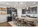 Modern kitchen with dark cabinetry, granite countertops, and a spacious island with seating at 4264 Bexley Village Dr, Land O Lakes, FL 34638