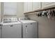 Well-equipped laundry room with a washing machine and dryer, white cabinets and a window at 4264 Bexley Village Dr, Land O Lakes, FL 34638