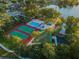 Aerial view showcasing community amenities including a pool, tennis courts, and playground near a lake at 455 Cypress Lake Ct, Oldsmar, FL 34677