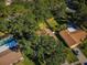 Aerial view of a property with mature trees, pool, and well-kept landscaping in a residential neighborhood at 455 Cypress Lake Ct, Oldsmar, FL 34677