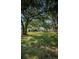 A picturesque backyard with mature trees shading a vast lawn, perfect for outdoor enjoyment at 455 Cypress Lake Ct, Oldsmar, FL 34677