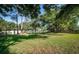 Expansive backyard featuring lush green grass, mature trees, and a privacy fence at 455 Cypress Lake Ct, Oldsmar, FL 34677