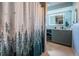Bathroom featuring a shower with a modern shower curtain, vanity with illuminated mirror at 455 Cypress Lake Ct, Oldsmar, FL 34677