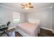 Cozy bedroom with a ceiling fan, bright window, and a comfortable-looking bed with a blanket at 455 Cypress Lake Ct, Oldsmar, FL 34677