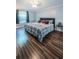 Comfortable bedroom featuring wood floors, a plush bed, and neutral decor at 455 Cypress Lake Ct, Oldsmar, FL 34677