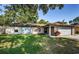 Inviting single-story home with a blue accent door, a well-kept lawn, and an attached garage at 455 Cypress Lake Ct, Oldsmar, FL 34677
