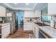 Bright kitchen with stainless steel refrigerator, white cabinets, marble countertops, and wood flooring at 455 Cypress Lake Ct, Oldsmar, FL 34677