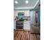 Kitchen with stainless steel appliances, wooden floor and white cabinets at 455 Cypress Lake Ct, Oldsmar, FL 34677
