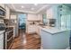 Bright kitchen featuring wooden floors, white cabinetry, stainless steel appliances, and adjacent dining area at 455 Cypress Lake Ct, Oldsmar, FL 34677