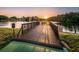 A wooden pier overlooks the serene lake, offering a peaceful spot to enjoy the sunset at 455 Cypress Lake Ct, Oldsmar, FL 34677