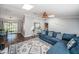 Comfortable living room featuring a blue sofa, skylight, and view of the dining area and laundry room at 455 Cypress Lake Ct, Oldsmar, FL 34677