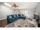 Bright living room featuring a plush blue sectional, patterned rug, and wood floors at 455 Cypress Lake Ct, Oldsmar, FL 34677