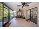 Enclosed patio with ceiling fans and an outdoor dining set for relaxing and entertaining at 455 Cypress Lake Ct, Oldsmar, FL 34677