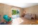 Bright living room featuring wood-look walls and sliding glass doors to outside space at 4609 10Th Street E Ct, Ellenton, FL 34222