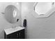 Compact powder room with a round mirror and hexagon window, creating an intimate space at 5032 Cypress Trace Dr, Tampa, FL 33624