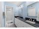 Bright bathroom featuring a double vanity with black countertops and a walk-in shower at 5032 Cypress Trace Dr, Tampa, FL 33624