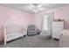 Cozy Bedroom with a white crib, plush chair, and soft pink walls at 5032 Cypress Trace Dr, Tampa, FL 33624