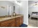 Well-lit Primary bathroom featuring double vanity, granite countertops, wood cabinets, and modern fixtures at 5319 W Trapnell Rd, Dover, FL 33527
