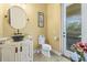 A delightful bathroom with a decorative sink, toilet, and outdoor access to a pool at 5319 W Trapnell Rd, Dover, FL 33527