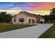 Exterior of home with two car garage under colorful sunset at 5319 W Trapnell Rd, Dover, FL 33527