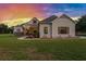 Charming one-story home with a beautifully landscaped front yard and a sunset backdrop at 5319 W Trapnell Rd, Dover, FL 33527