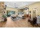 Open living space with wood beams, stone fireplace, and sliding glass doors to the lanai at 5319 W Trapnell Rd, Dover, FL 33527