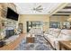 Cozy living room features a stone fireplace, tray ceiling, and views of the backyard at 5319 W Trapnell Rd, Dover, FL 33527