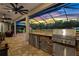 Screened outdoor kitchen and patio with stone countertops and stainless steel grill at 5319 W Trapnell Rd, Dover, FL 33527