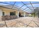 Spacious screened lanai featuring an outdoor kitchen and large seating area at 5319 W Trapnell Rd, Dover, FL 33527