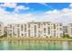 Waterfront condo building featuring multiple stories, balconies, and lush landscaping in a picturesque setting at 6020 S Shore Blvd # 709, Gulfport, FL 33707
