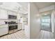 Bright kitchen featuring white cabinetry and appliances, next to a hallway at 6020 S Shore Blvd # 709, Gulfport, FL 33707