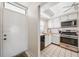Well-lit kitchen with white cabinets, stainless steel appliances, and tiled flooring adjacent to the front door at 6020 S Shore Blvd # 709, Gulfport, FL 33707