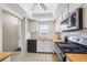 Modern kitchen with white cabinets, stainless steel appliances, and tiled flooring with an overhead fan at 6020 S Shore Blvd # 709, Gulfport, FL 33707
