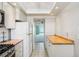 Kitchen with white cabinetry and appliances that leads to another room at 6020 S Shore Blvd # 709, Gulfport, FL 33707