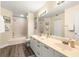 Bathroom features a double vanity, framed mirror, and a shower-tub combination with beach themed art at 6131 Bahia Del Mar Blvd # 241, St Petersburg, FL 33715