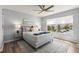 Bedroom with a neutral color palette, a ceiling fan, and a large window overlooking a parking area and palm trees at 6131 Bahia Del Mar Blvd # 241, St Petersburg, FL 33715