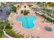 Aerial view of a community pool area with lounge chairs, landscaped surroundings, and a jacuzzi spa at 6131 Bahia Del Mar Blvd # 241, St Petersburg, FL 33715
